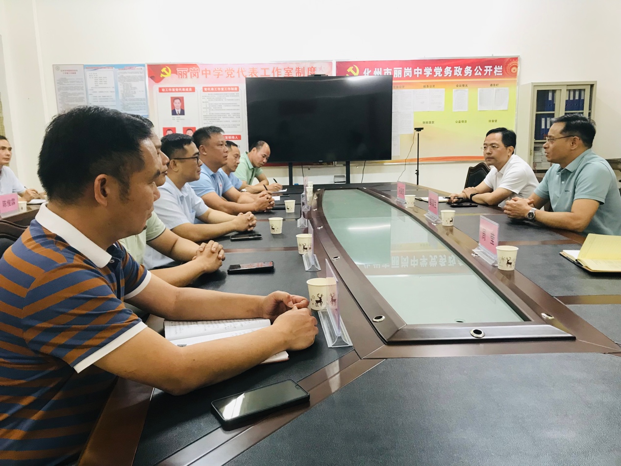 一群人看着桌子上的电脑描述已自动生成